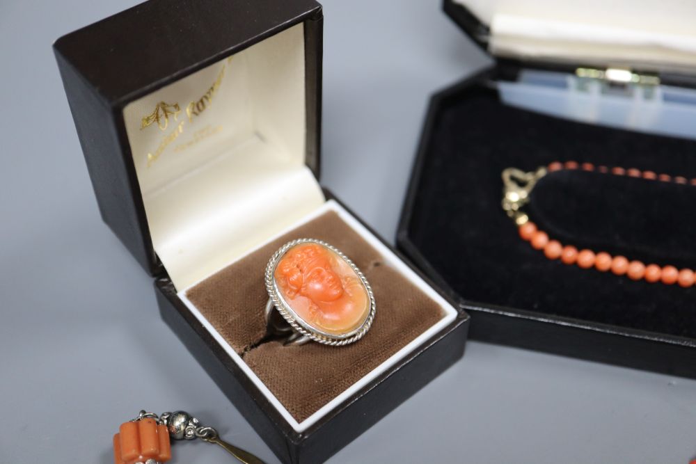 A white metal and carved coral set oval dress ring and three assorted necklaces.